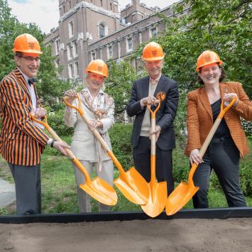 President Eisgruber, Wendy and Eric Schmidt, and Jen Rexford don orange hard hats and grab orange shovels for a ceremonial groundbreaking