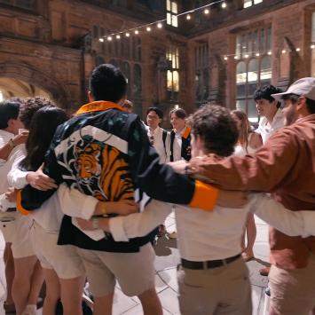 Princeton alumni in a circle, with arms around each other.