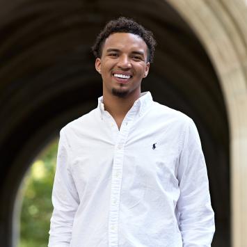 D'Schon Simmons smiling in front of Princeton campus arch.
