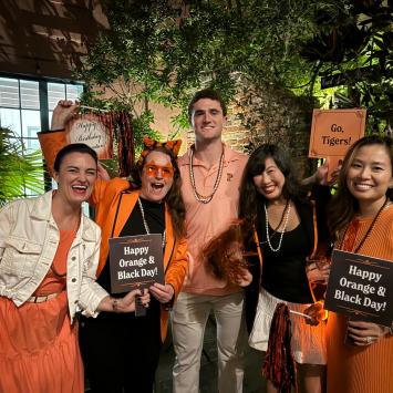 Members of the Princeton Alumni Association of New Orleans gather in orange and black 