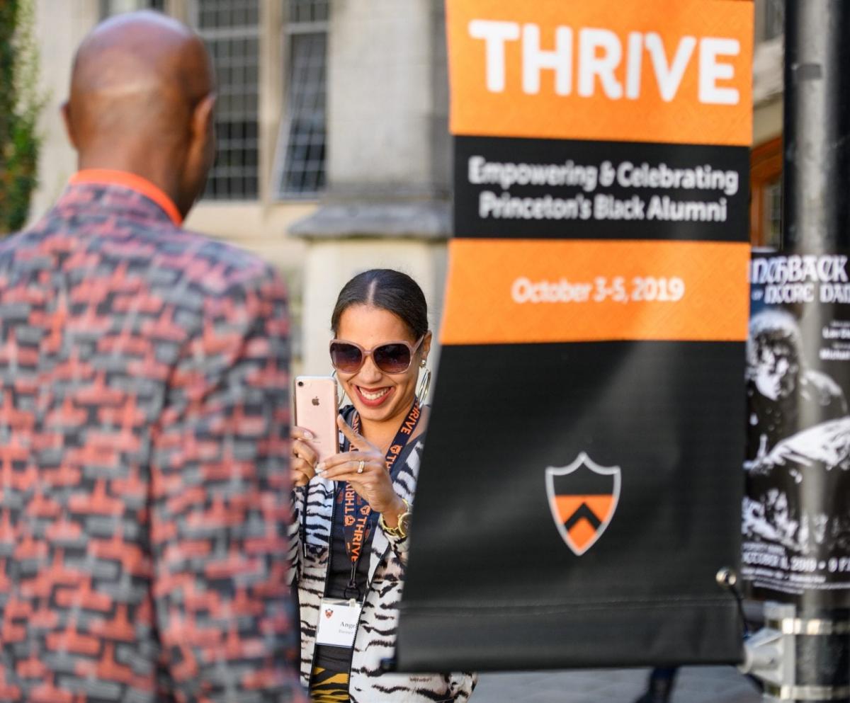 Alumni at Thrive conference outdoors by Thrive signage
