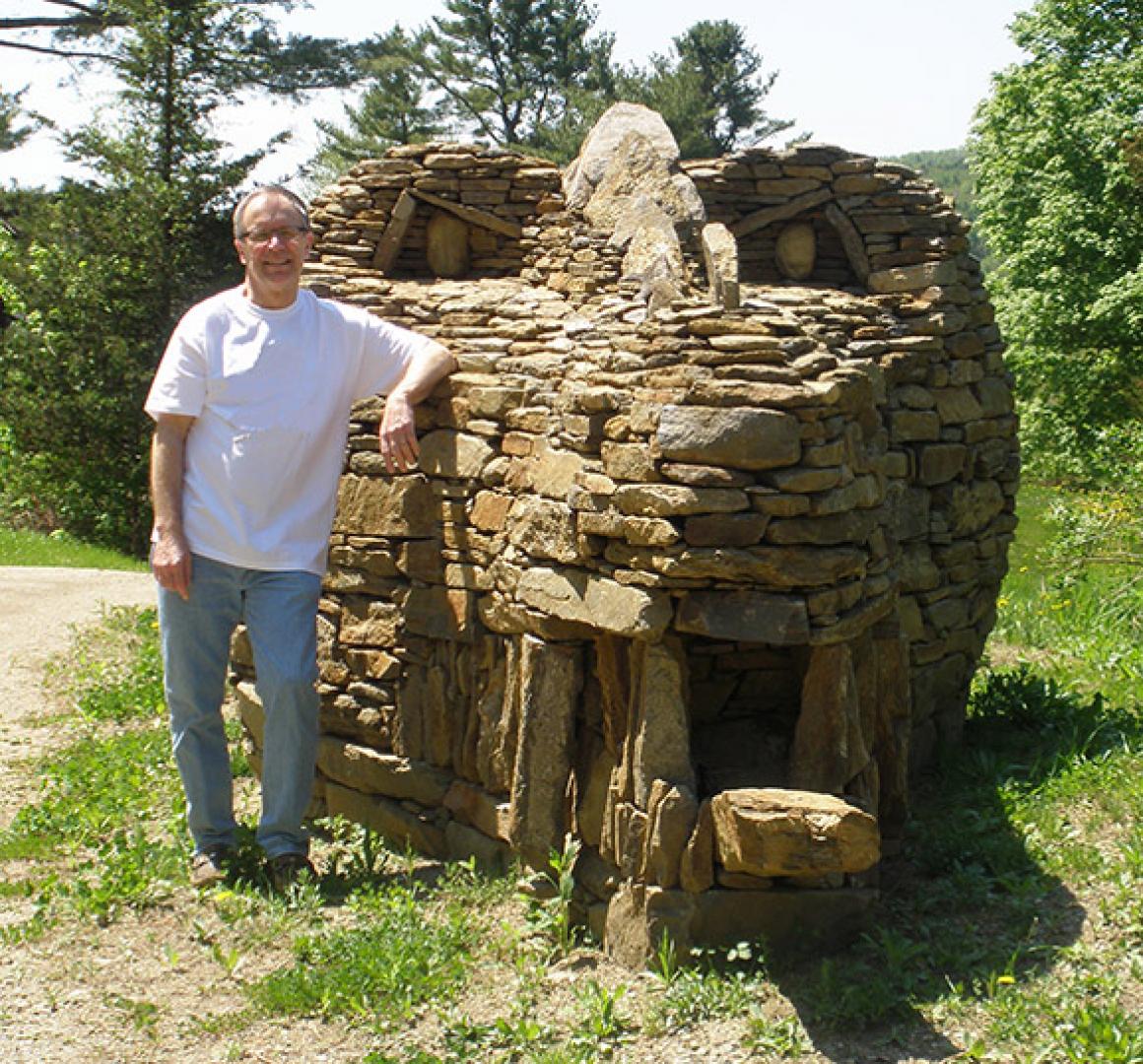 Ray Hartman '69 stands beside the stone dragon he designed.