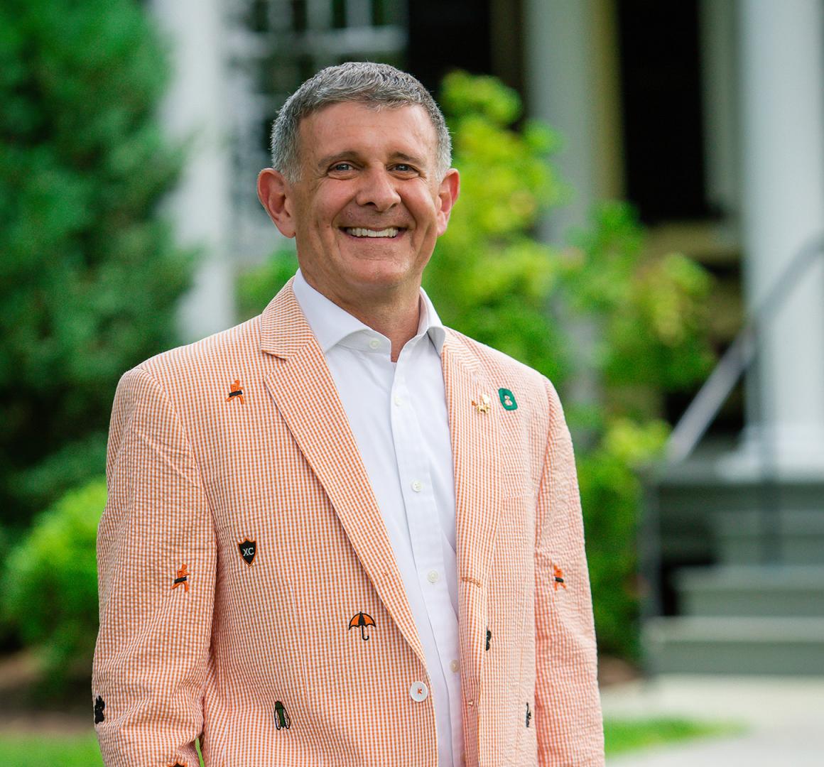 Ryan Ruskin, wearing his class jacket, in front of Maclean House