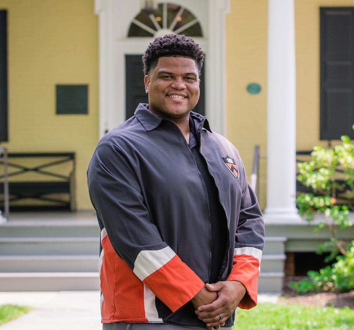 Eric Plummer from the Class of 2010, standing in front of Maclean House on the Princeton campus