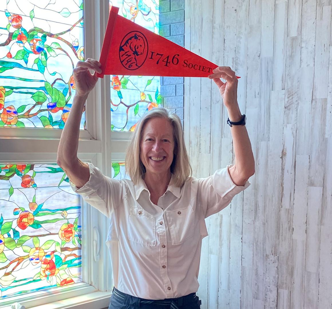 Beth Gilson holds a 1746 Society pennant