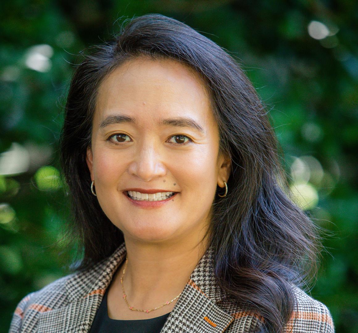 Close-up portrait of April Chou with leafy green background