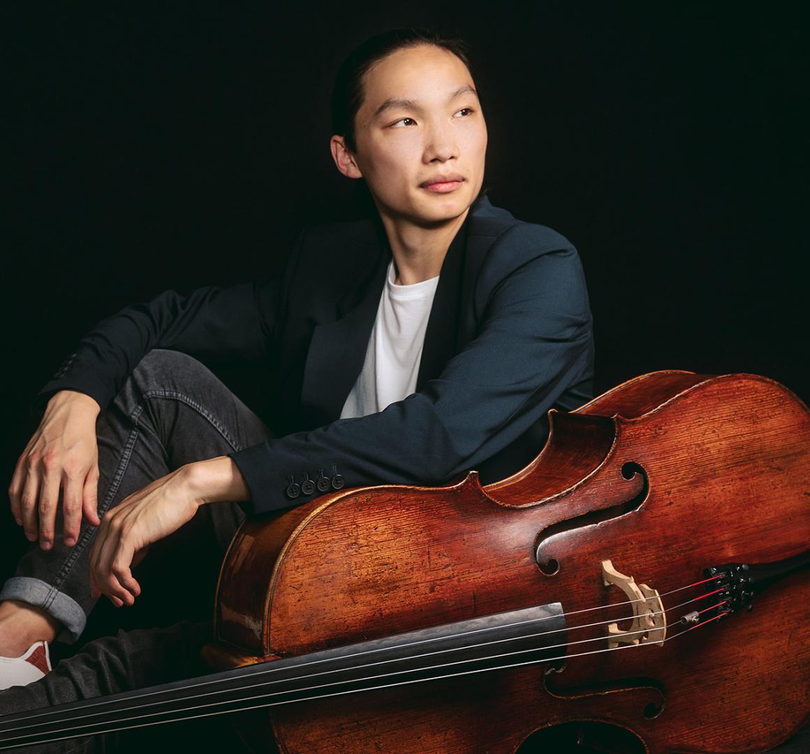 Leland Ko, sitting on the floor next to his cello