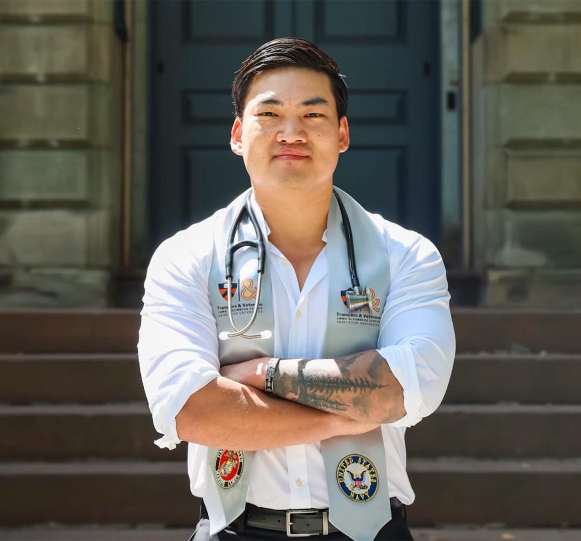 Luke Hixson stands in front of Nassau Hall, with a stethoscope hanging around his neck