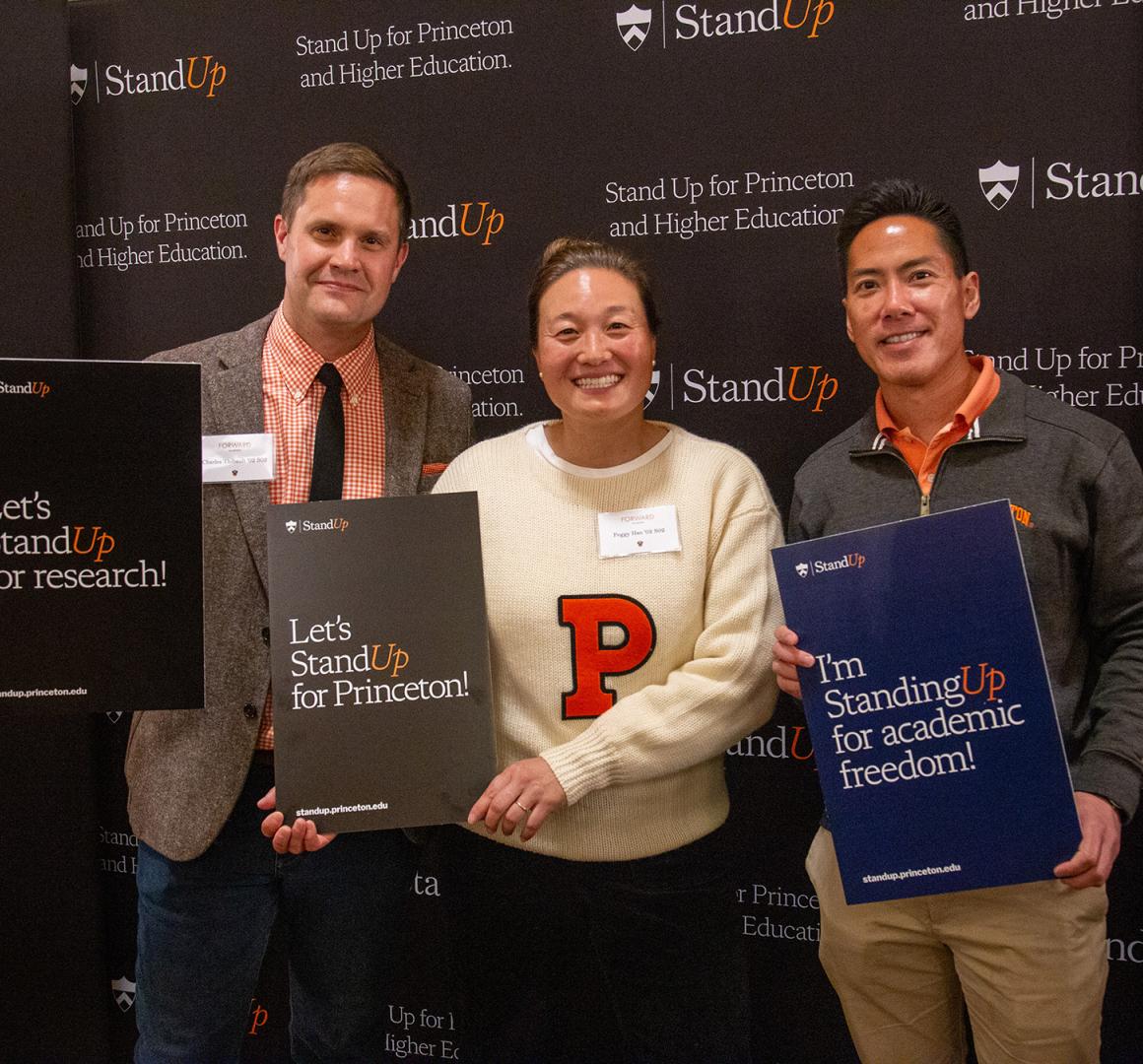 Three alums holding Stand Up for Princeton signs