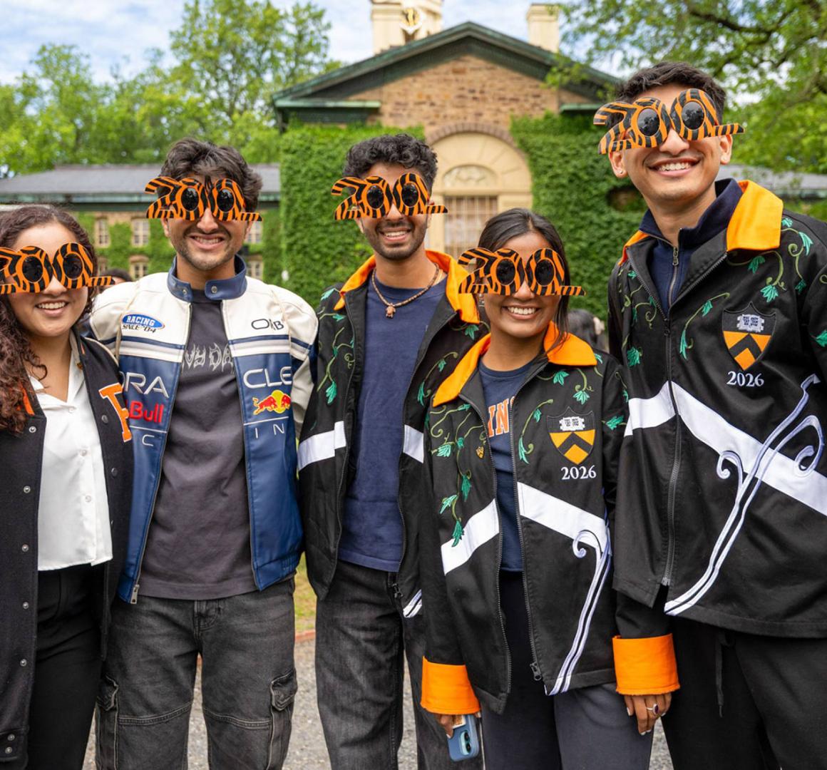 Five younger alumni wearing special 200 anniversary sunglasses while standing in front of Nassau Hall