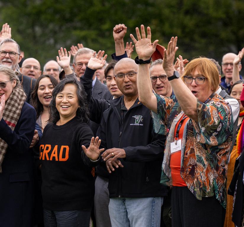 Alumni of the Graduate School woot and holler on Poe Field before a group photo during the Many Minds conference.