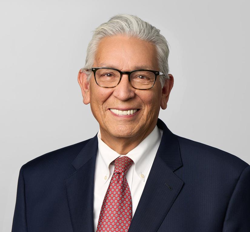Kevin Gover smiling, wearing glasses and tie. 