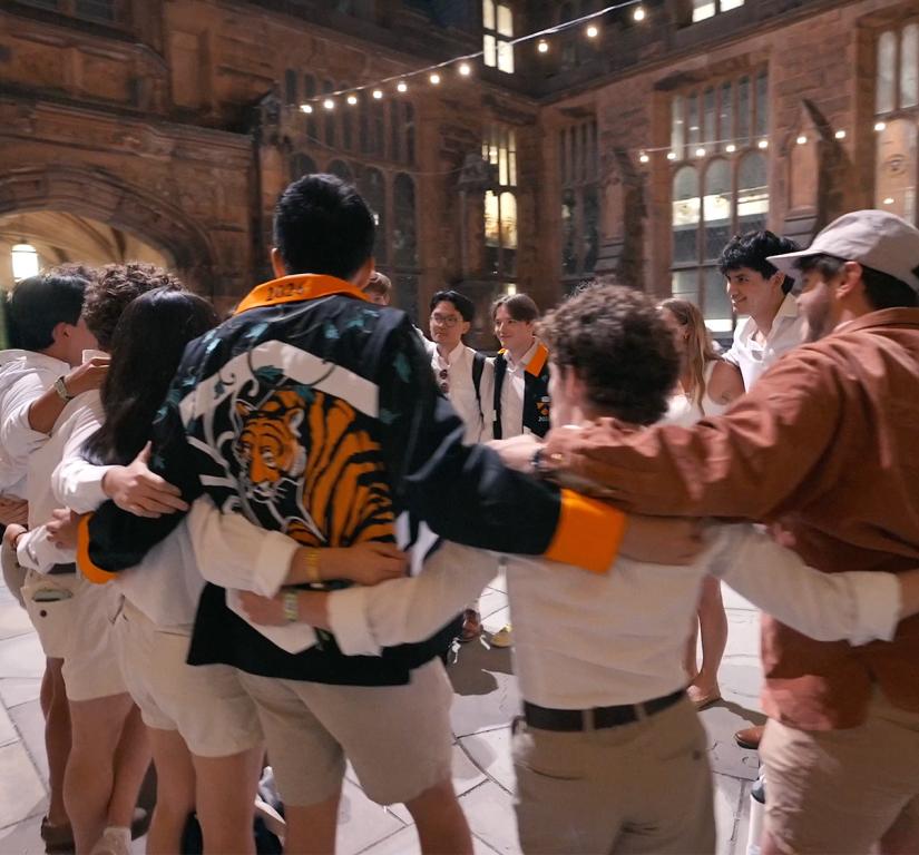 Princeton alumni in a circle, with arms around each other.
