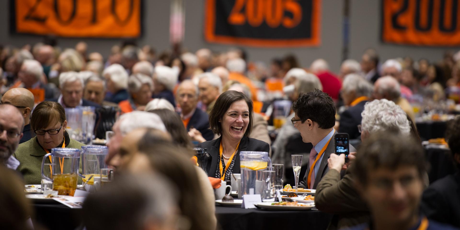 Alumni during Alumni Day in Jadwin Gym sitting at tables