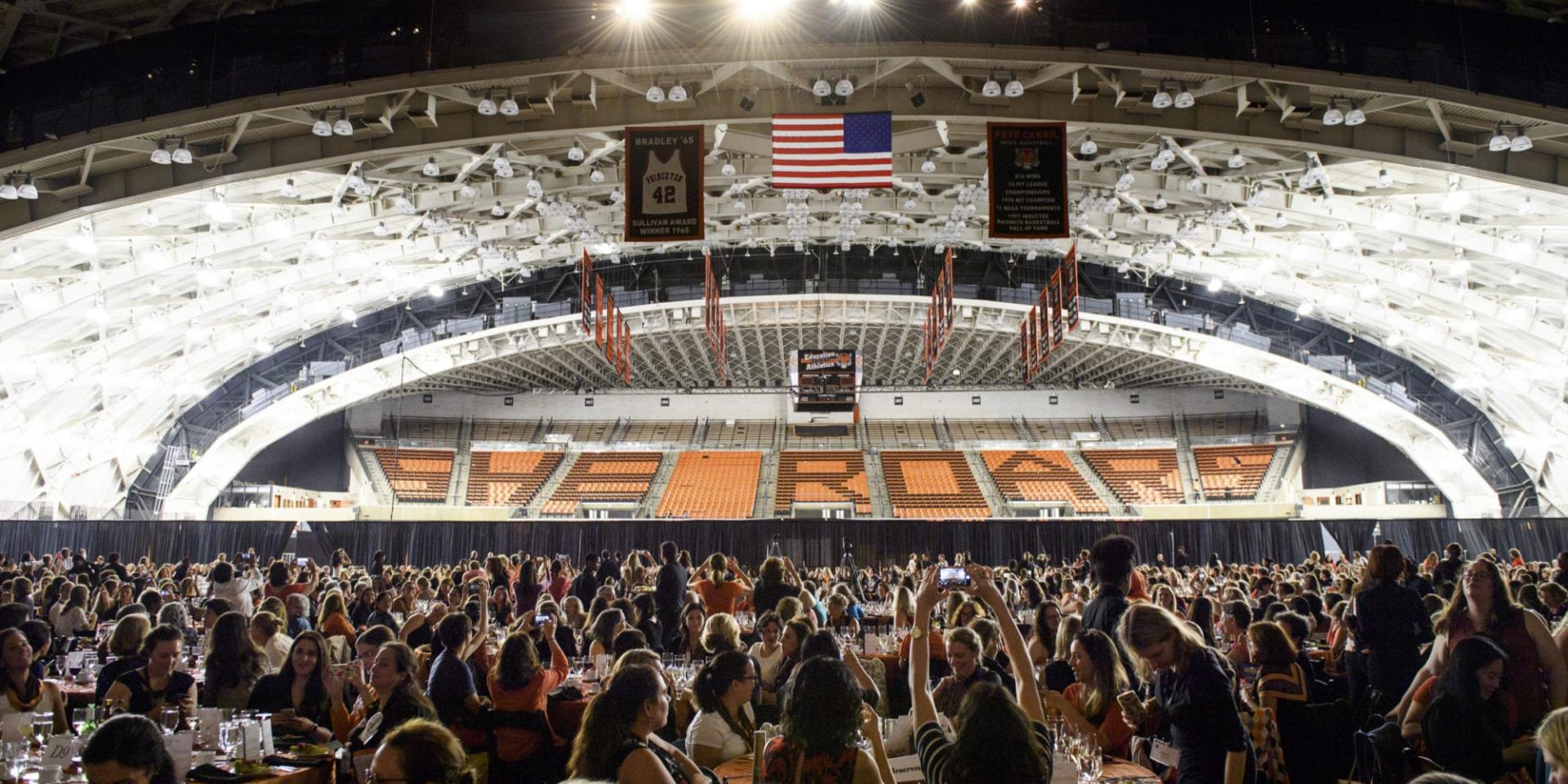 Long shot of She Roars conference in Jadwin Gym with sign that reads She Roars
