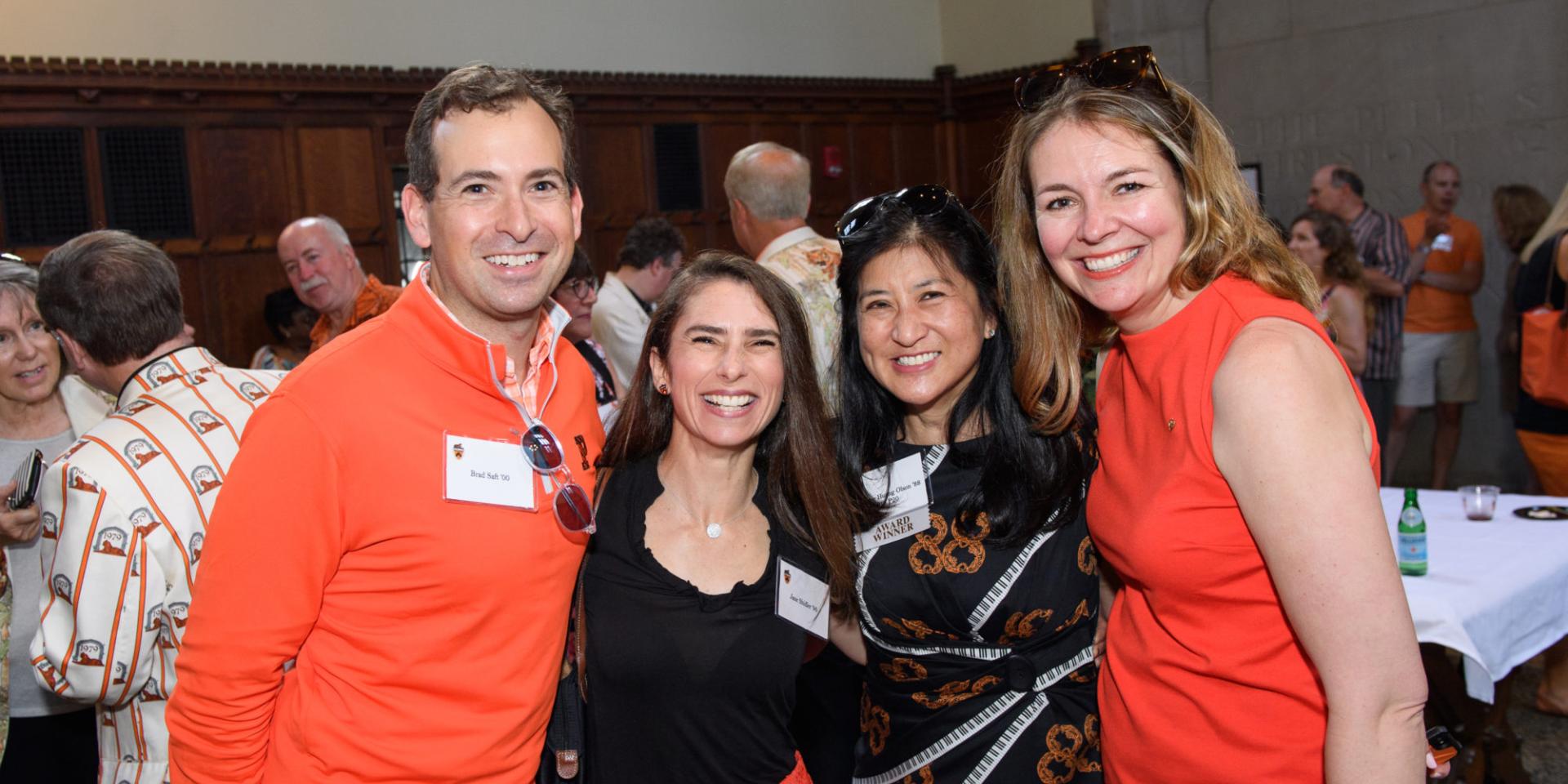 Four Princeton alumni wearing orange and black