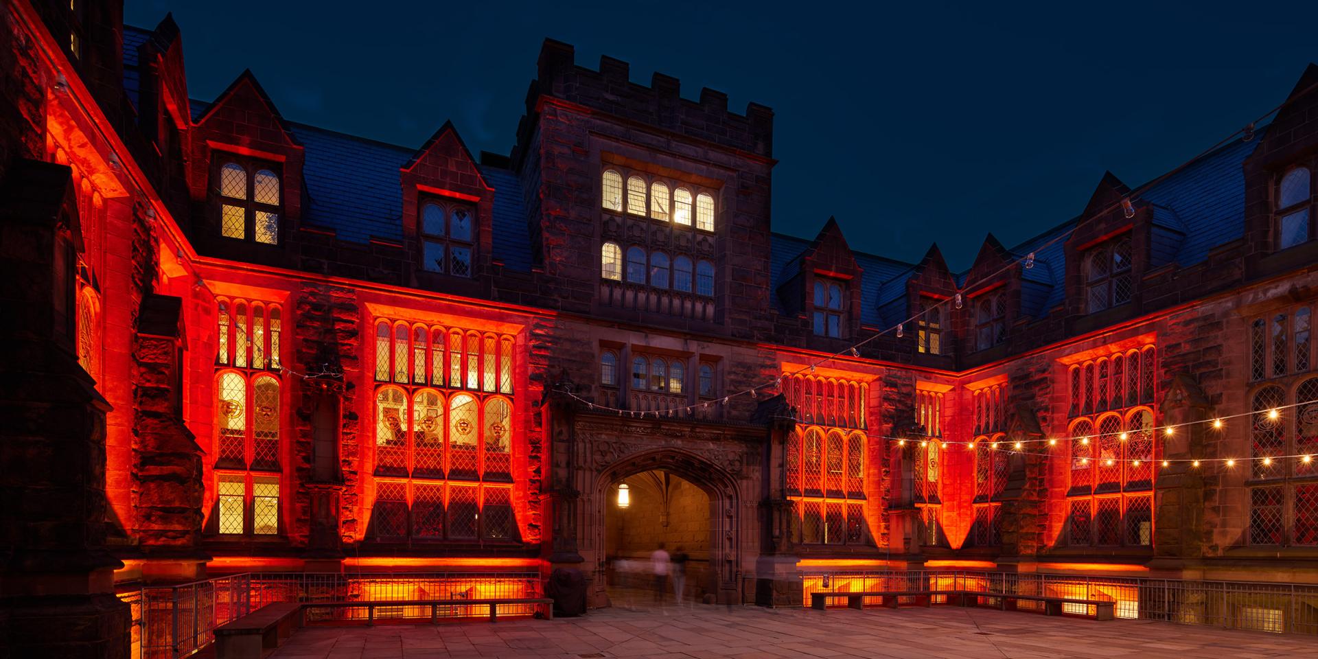 East Pyne Hall, at night, bathed in orange lights