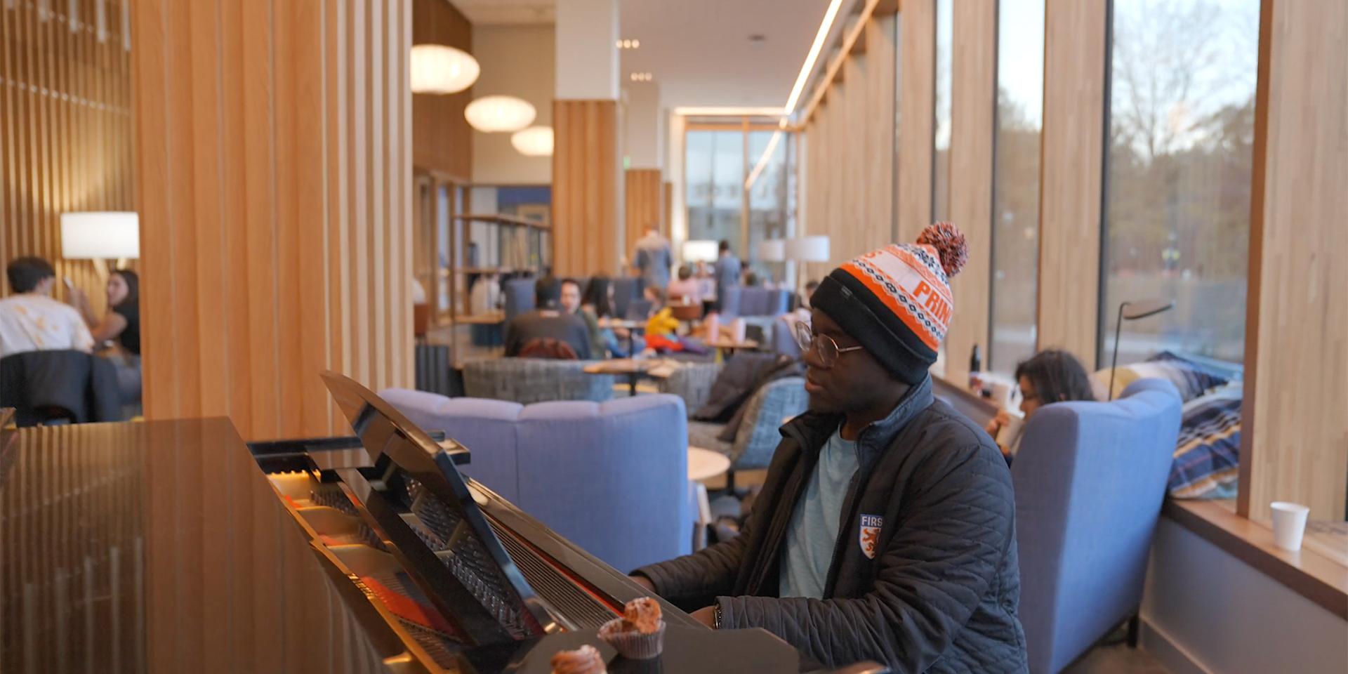 A Black Princeton student plays the piano in one of the new residential colleges