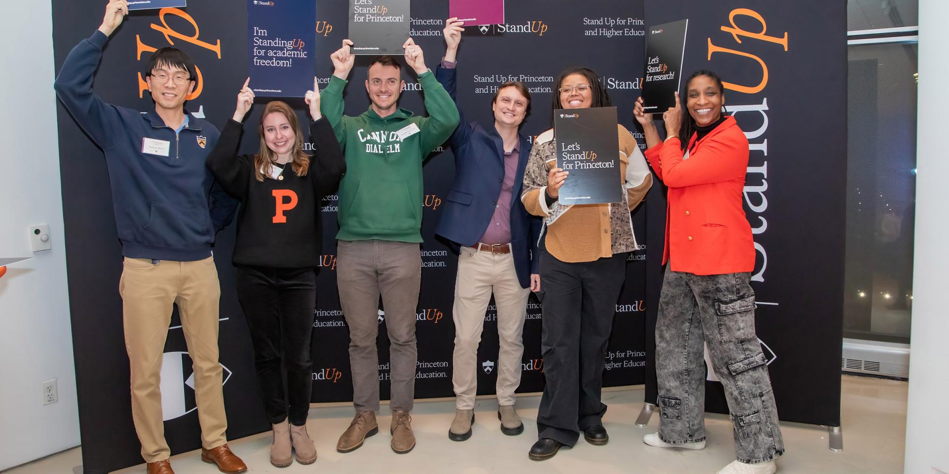 Alumni pose with Stand Up for Princeton signs