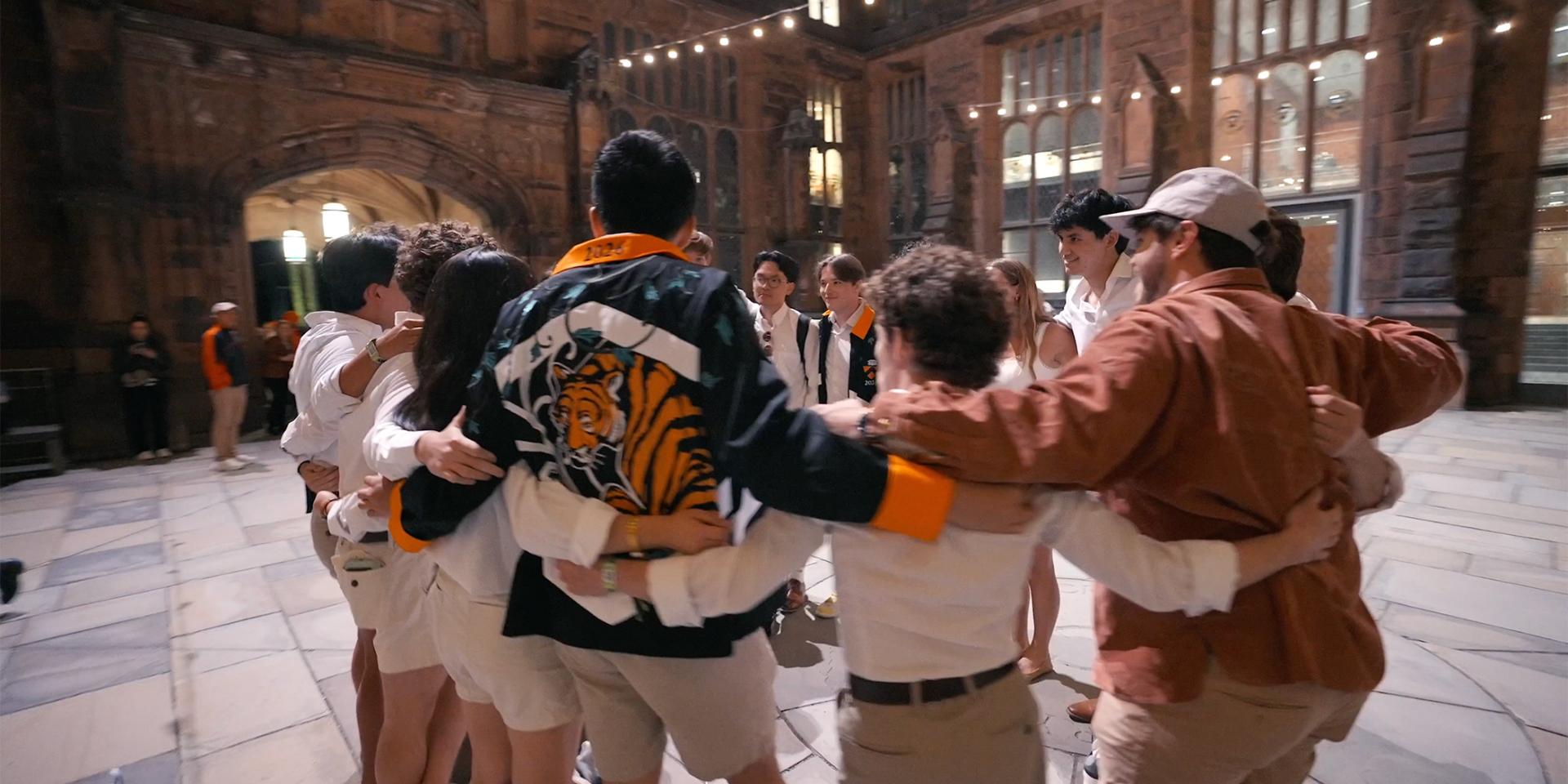 Princeton alumni in a circle, with arms around each other.