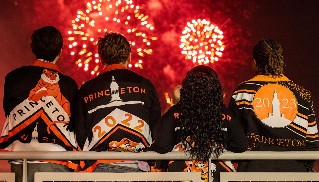 Three young alumni watch the fireworks at Reunions