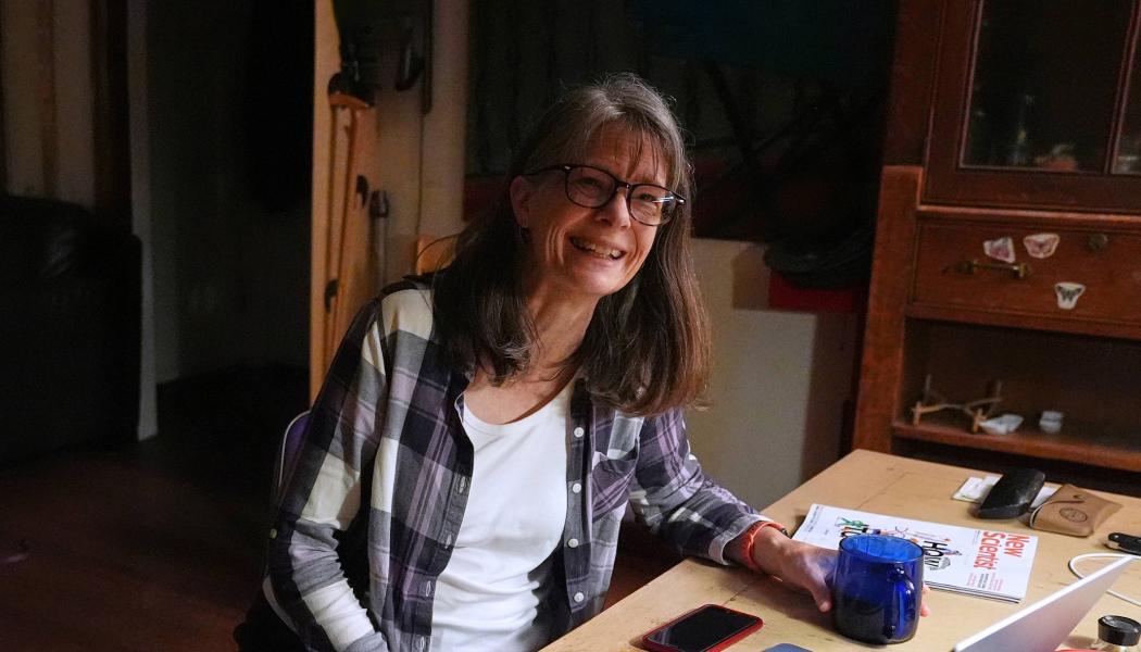 Mary Brunkow seated at her home desk, reacting to winning a Nobel.