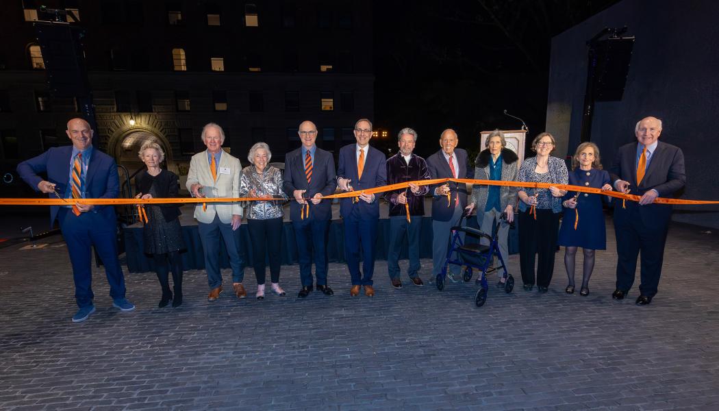 University officials and alumni hold and cut an orange ribbon to dedicate the new Art Museum.