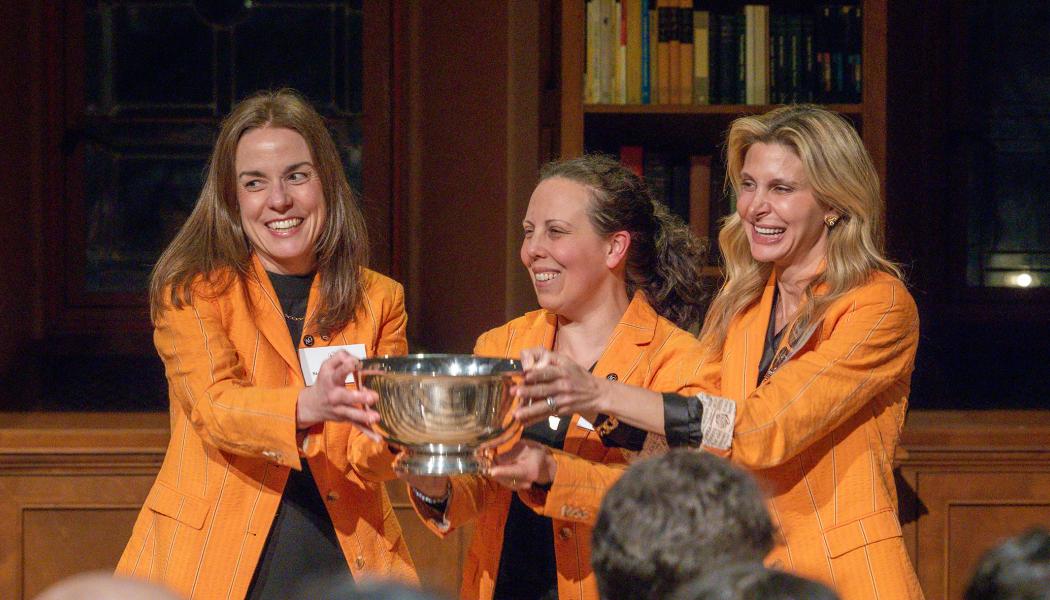 Wearing identical orange jackets, Tiffany Madigan, Stephanie Ramos and Alexis Moses proudly hold the Class of 1926 Trophy.