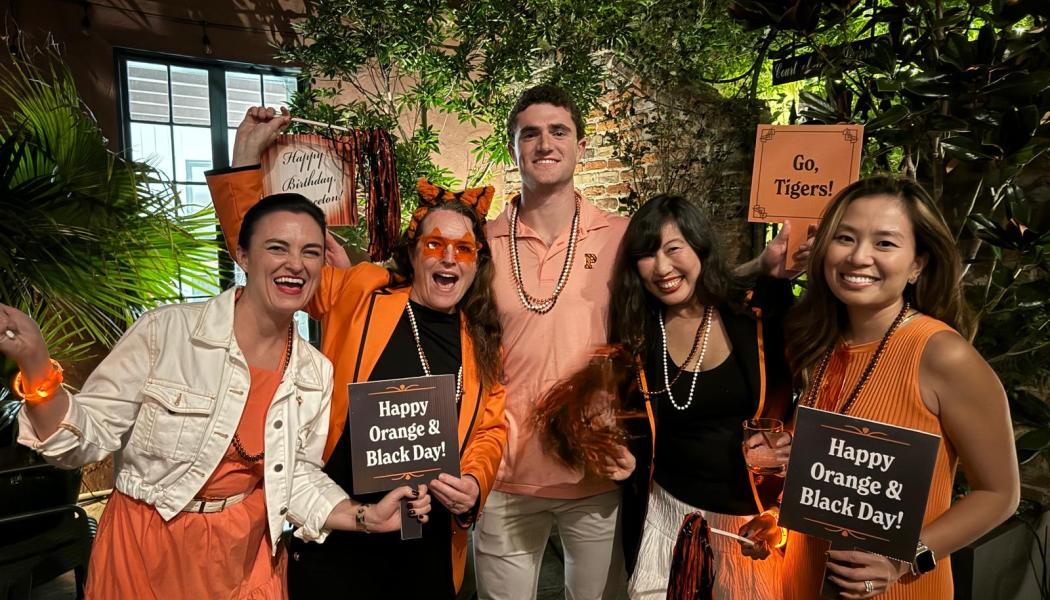 Members of the Princeton Alumni Association of New Orleans gather in orange and black 