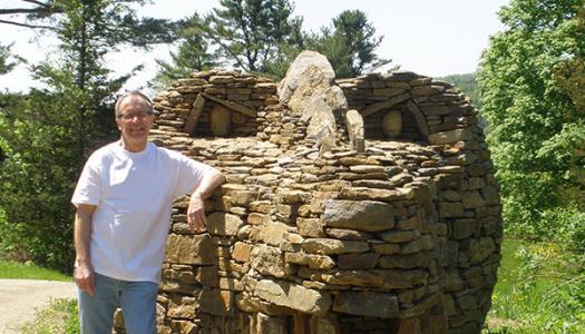 Ray Hartman '69 stands beside the stone dragon he designed.