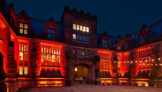 East Pyne Hall, at night, bathed in orange lights