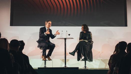 President Eisgruber '83, on stage in London, speaking with Razia Iqbal, BBC news anchor