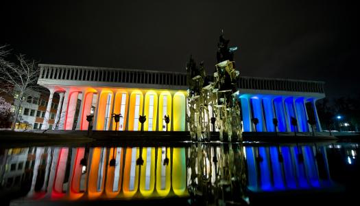 Robertson Hall at night, illuminated by rainbow lights