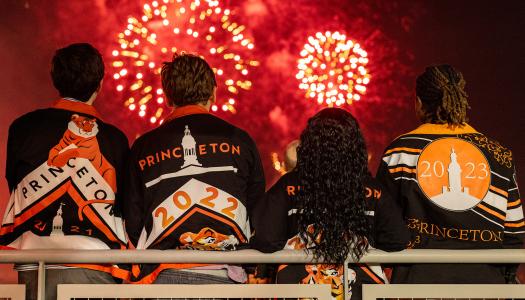Three young alumni watch the fireworks at Reunions