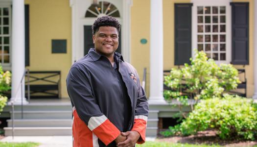 Eric Plummer from the Class of 2010, standing in front of Maclean House on the Princeton campus