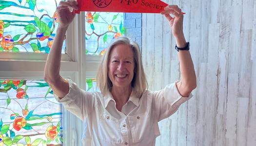 Beth Gilson holds a 1746 Society pennant