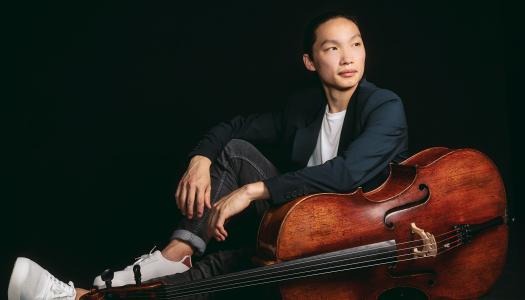 Leland Ko, sitting on the floor next to his cello