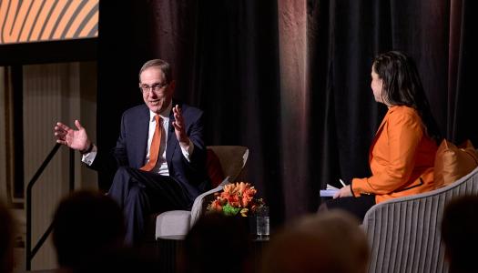 President Eisgruber gestures with his hands to make a point in his conversation on stage with Melissa Wu.
