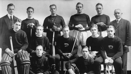 Black and white team photo of the Princeton ice hockey team, with Hobey Baker seated in the middle