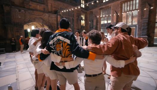 Princeton alumni in a circle, with arms around each other.