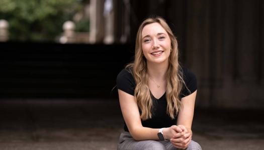 Alyssa Lloyd, sitting on the steps of a Princeton campus academic building. 