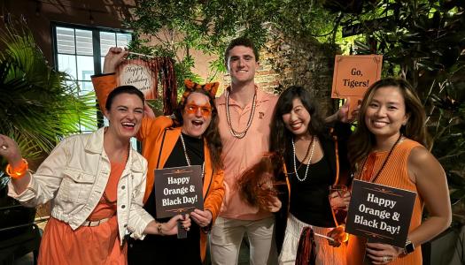 Members of the Princeton Alumni Association of New Orleans gather in orange and black 