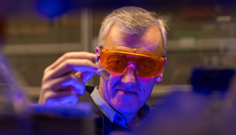 David MacMillan, wearing tinted orange lab goggles.