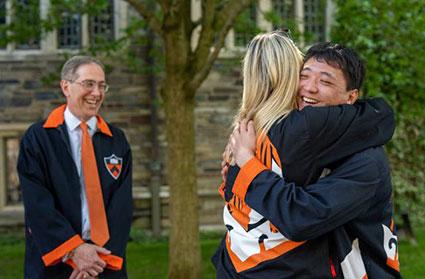 Morgan Kirkpatrick (center) and Andrew Sun (right) embrace.