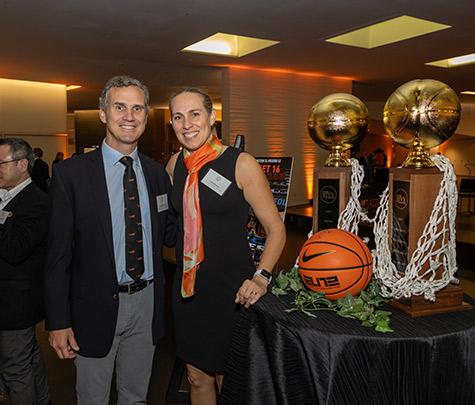 Mitch Henderson and Carla Berube, Princeton's women's basketball coach, pose next to the Ivy League trophies their teams won in 2023.