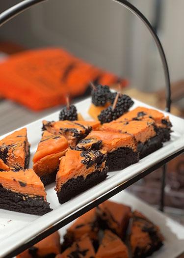 a tray holds servings of brown and orange brownies