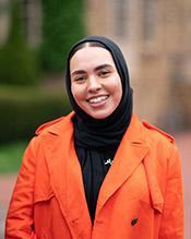 Chebbi Aisha, smiling, wearing a bright orange raincoat