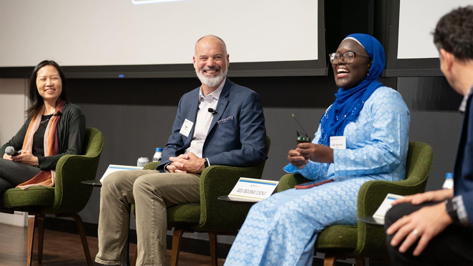 Two women and two men smile during a panel discussion.