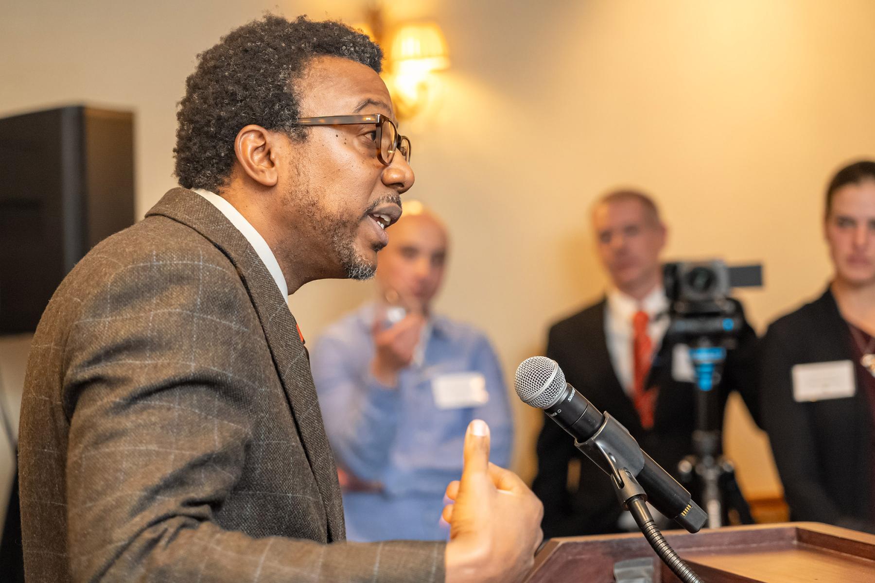 Rodney Priestley, dean of the Graduate School, speaks to alumni from a podium