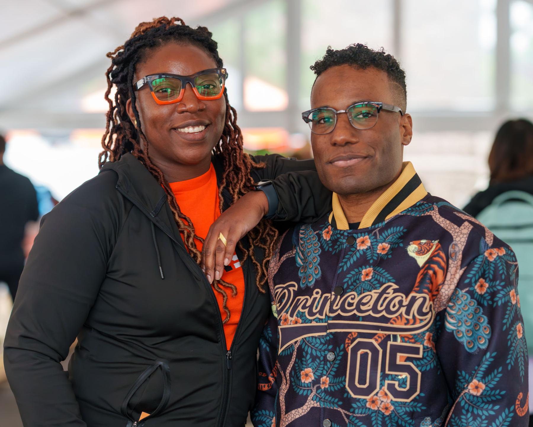 Class of 2005 alumni show their style: Michen Tah (left) wears orange and black glasses while Lawrence Henderson (right) shows off the class’ 20th Reunion jacket.